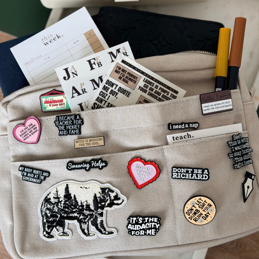 Pouch with various pins and notes on a surface