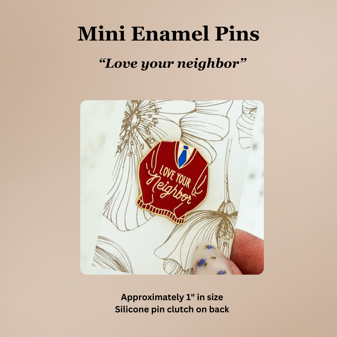 Mini enamel pin with 'Love your neighbor' message on a beige background