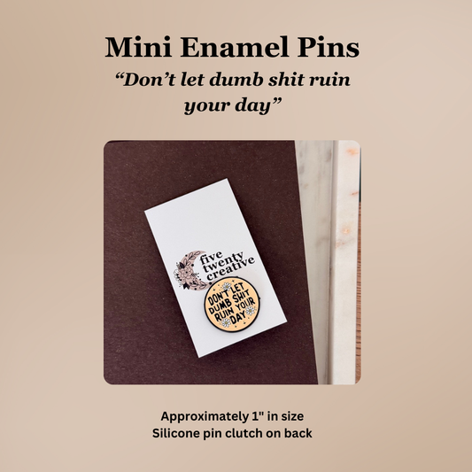 Mini enamel pin with motivational quote on a beige background
